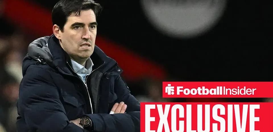 Coach observing match with arms crossed on sideline