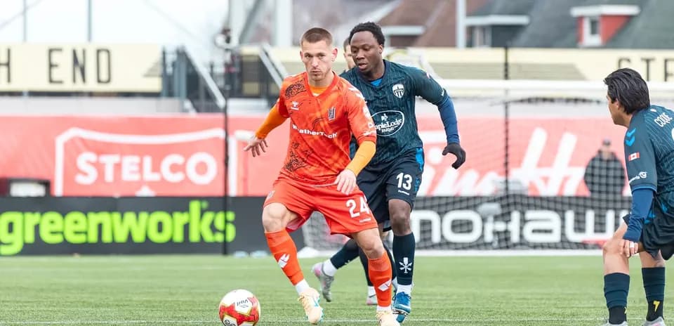 Players competing for the ball in football match