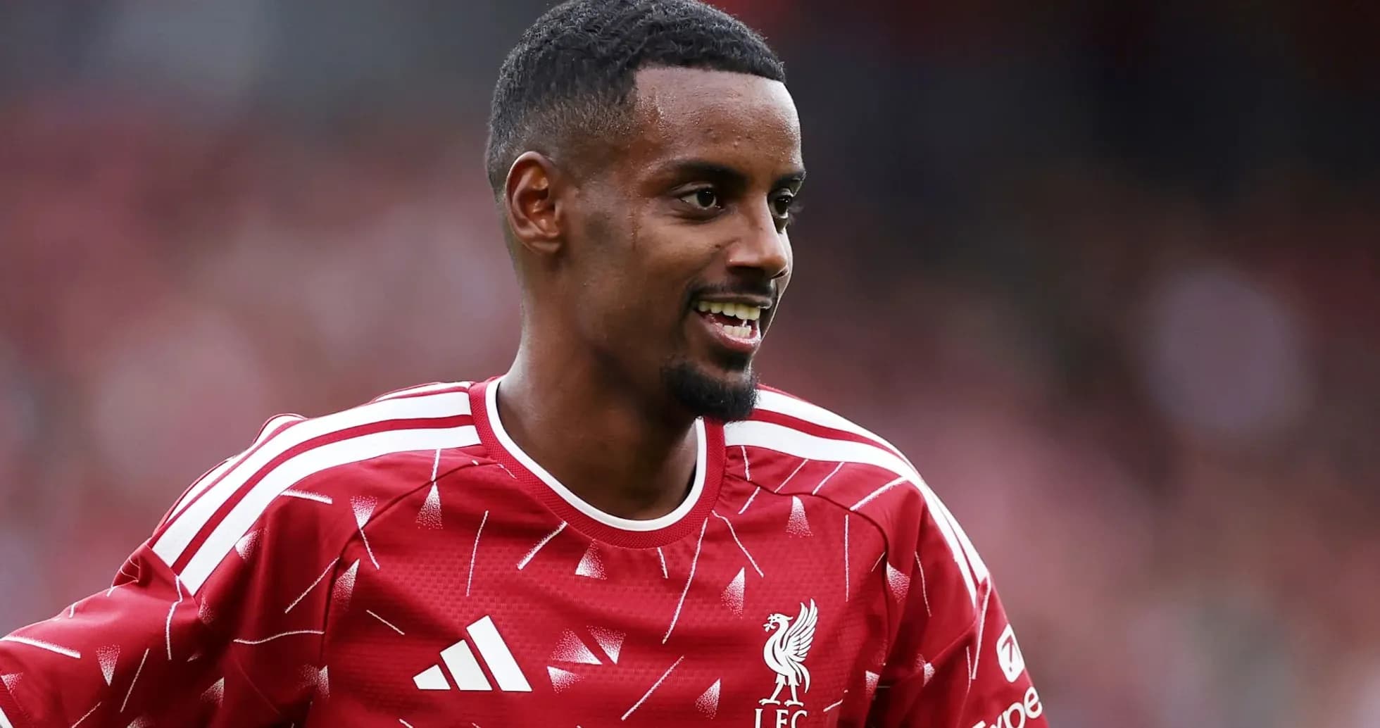 Player in Liverpool kit smiling during warm-up