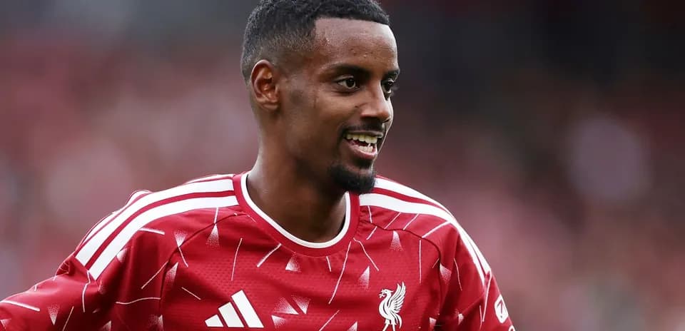 Player in Liverpool kit smiling during warm-up