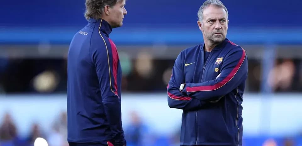 Two coaches discussing strategy on the pitch