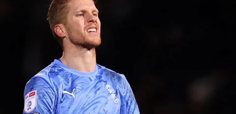 Goalkeeper in blue kit during match action