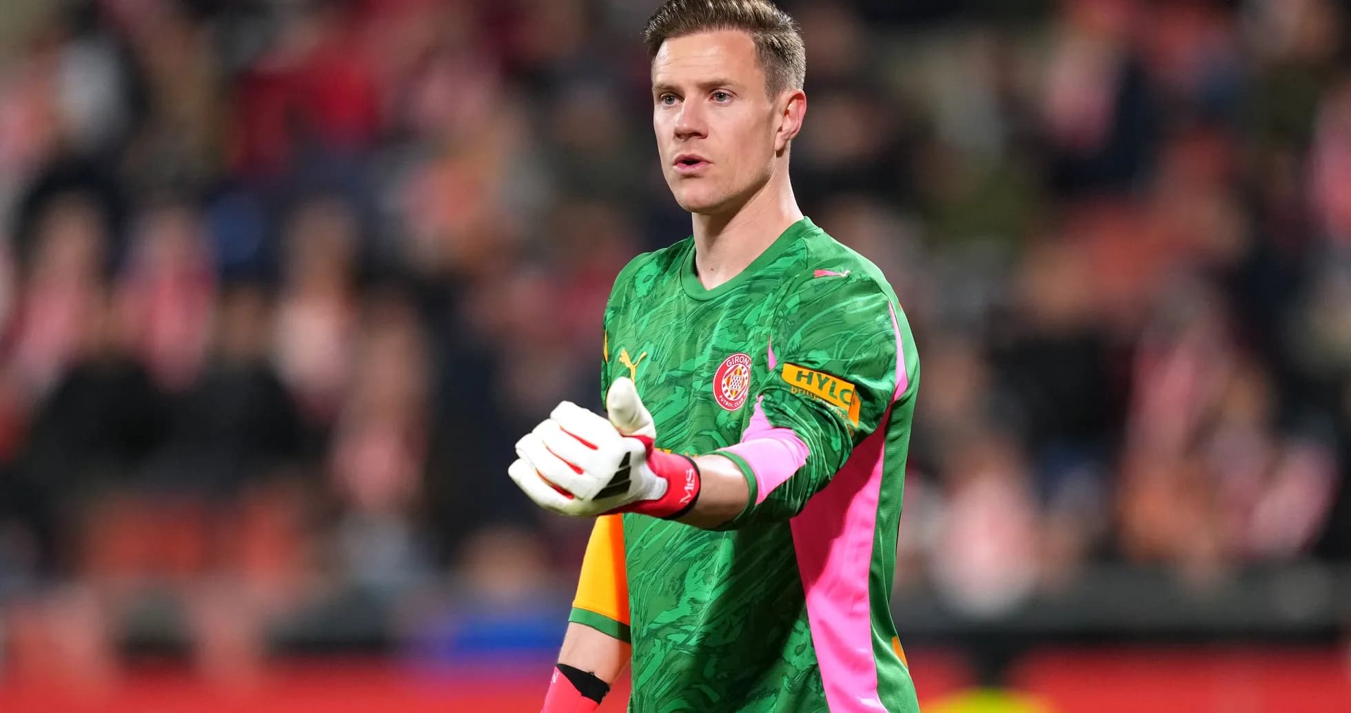 Goalkeeper gesturing during a match in green kit