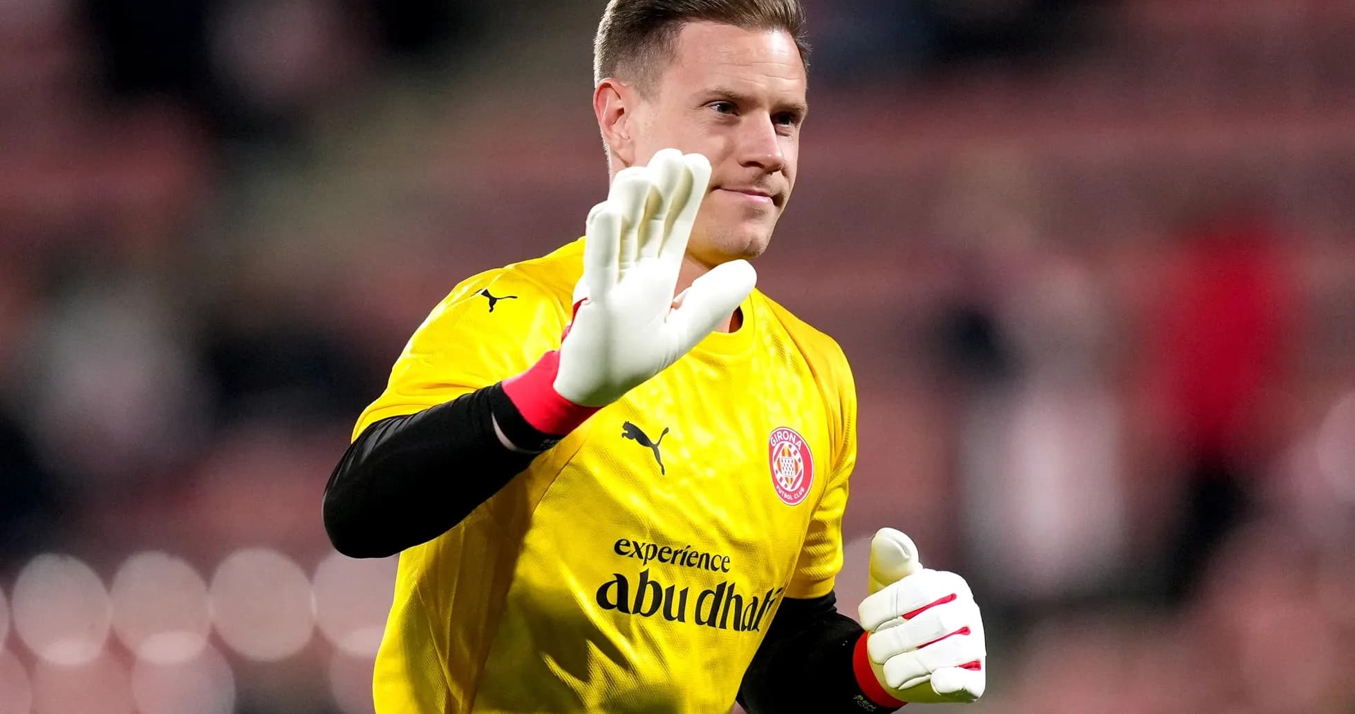 Goalkeeper waving in yellow uniform before match