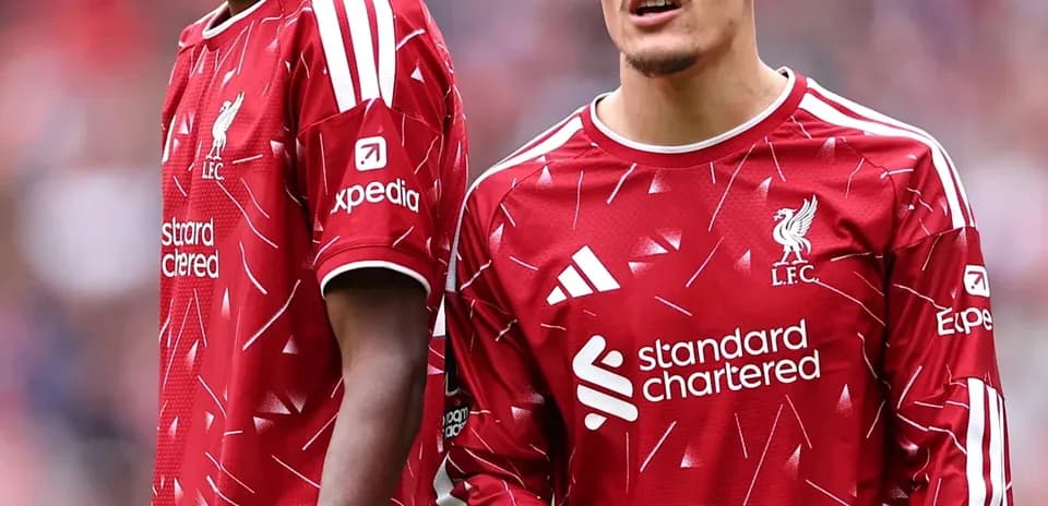 Two Liverpool players in red jerseys on field