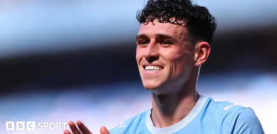 Player smiling and applauding on the pitch
