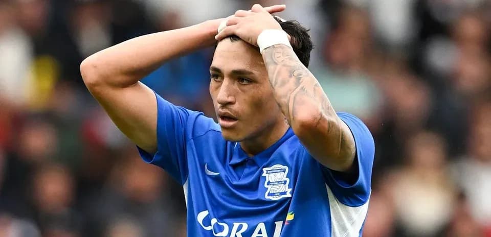 Player in blue jersey holding head in distress