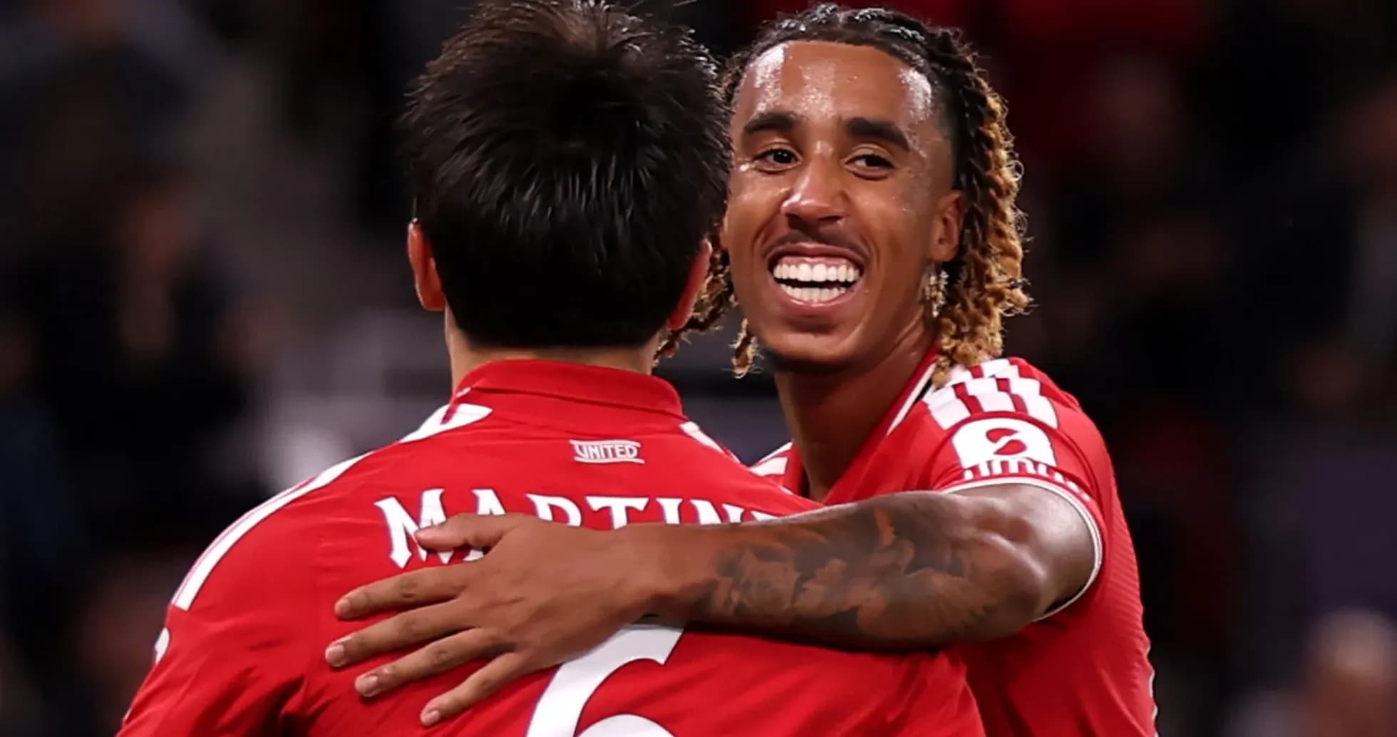 Two players celebrating a goal in red jerseys