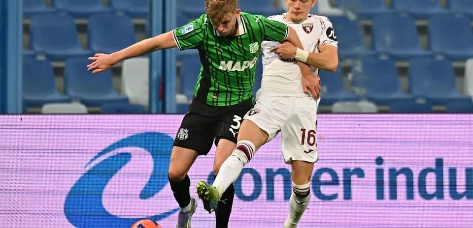 Sassuolo player challenging Torino opponent for the ball