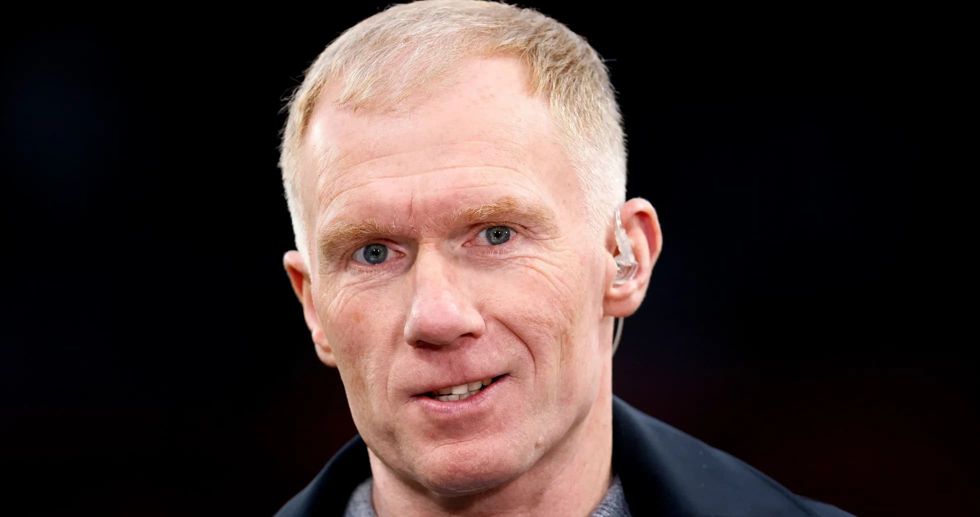 Man with short hair speaking into microphone