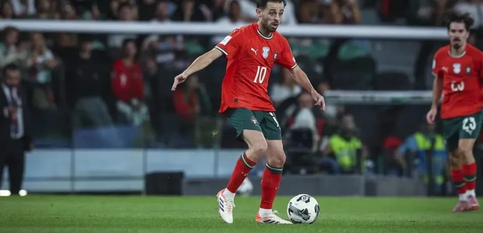 Player in red jersey dribbling the ball on field