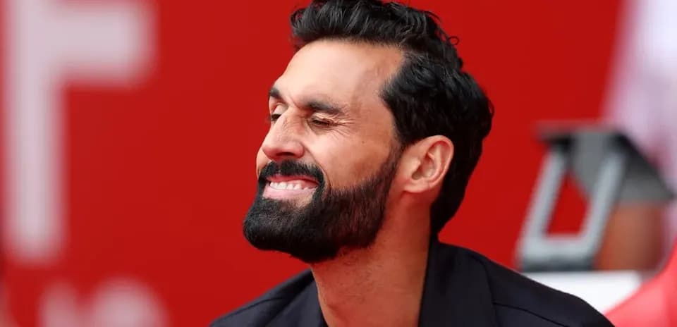 Man smiling with beard, seated on bench