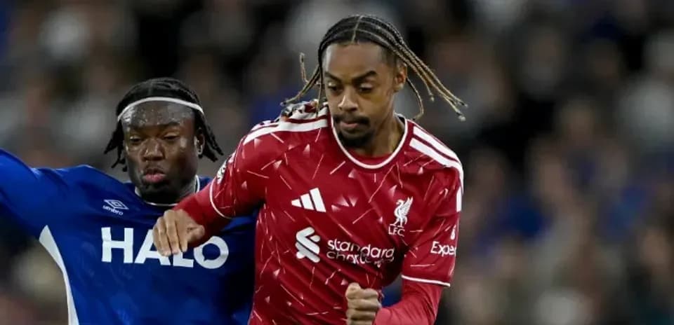 Liverpool player evading tackle from opponent during match