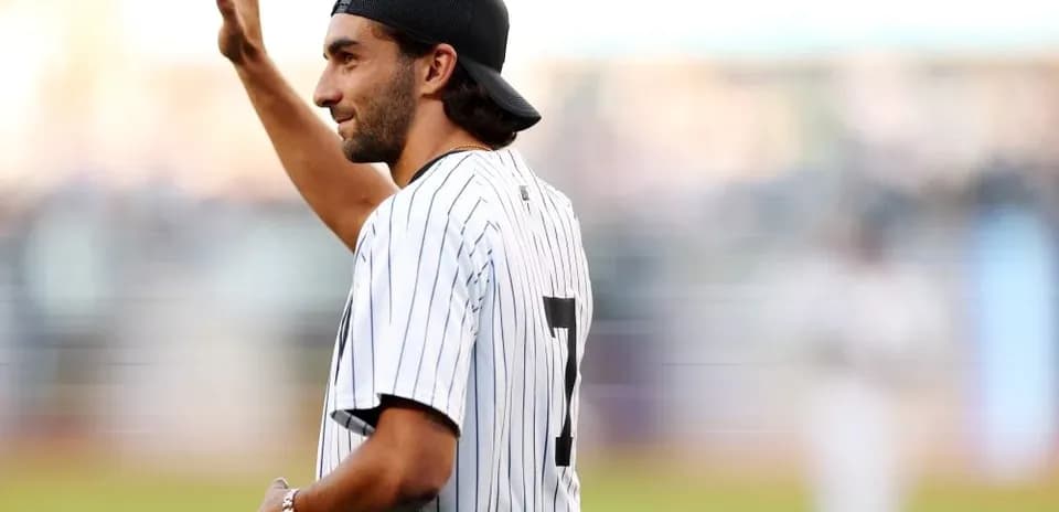 Man in baseball jersey waving to crowd