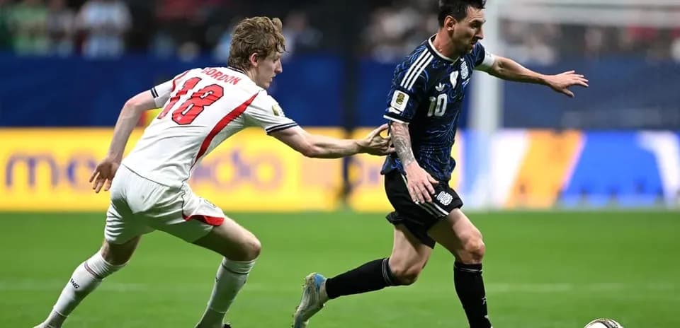 Player wearing blue dribbling past opponent in white