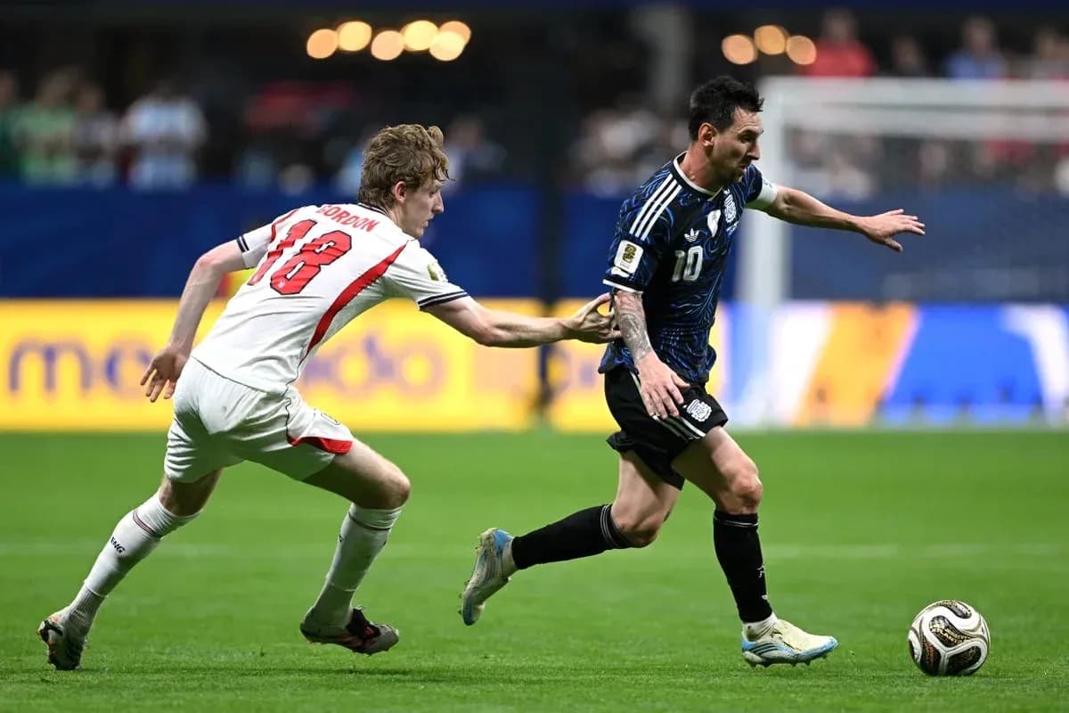 Player wearing blue dribbling past opponent in white