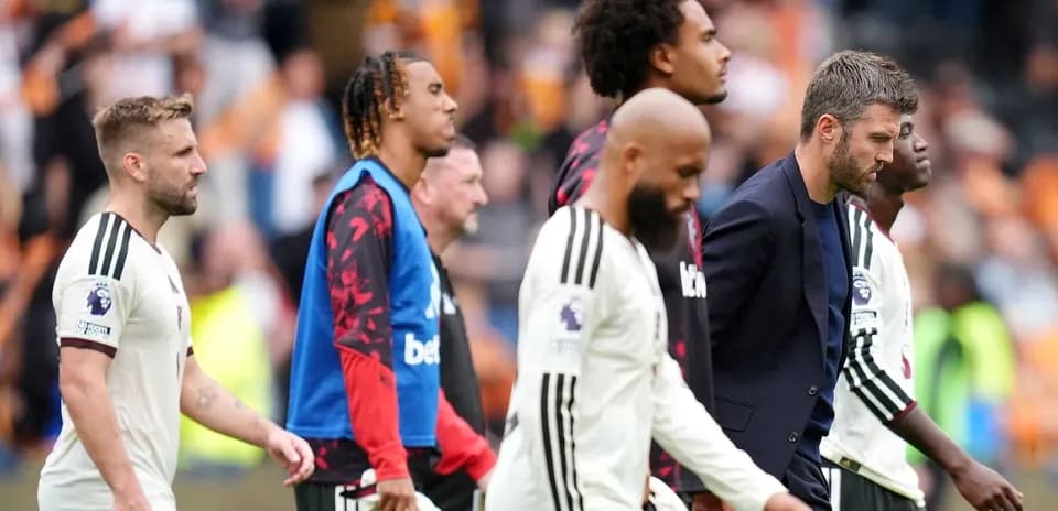 Players and coach leaving the pitch after match