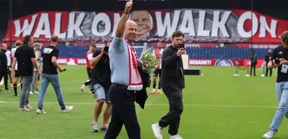 Man waving with bouquet in front of large banner