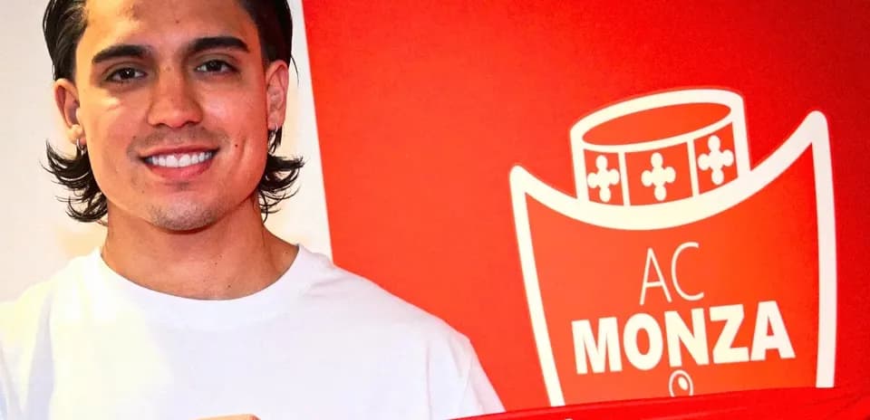 Player holding AC Monza jersey in front of logo