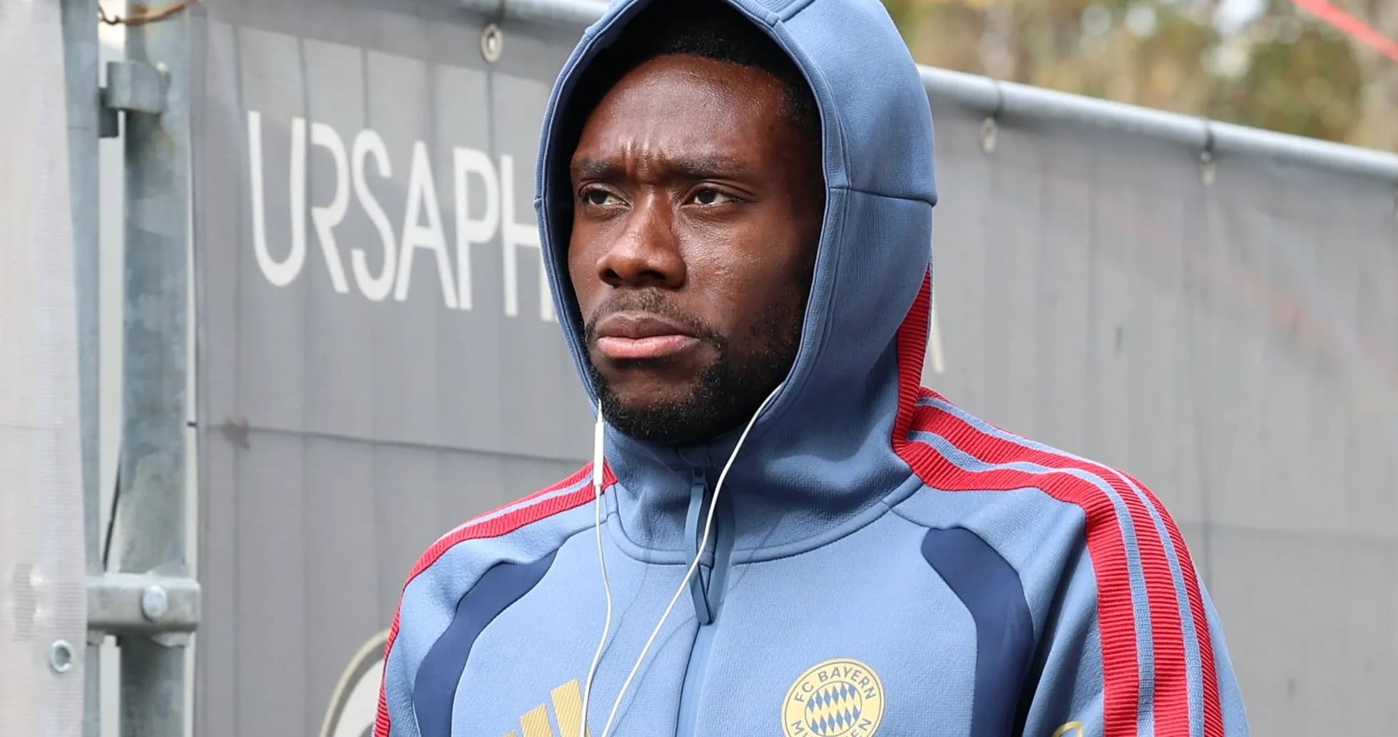 Player wearing Bayern Munich hoodie walking with headphones