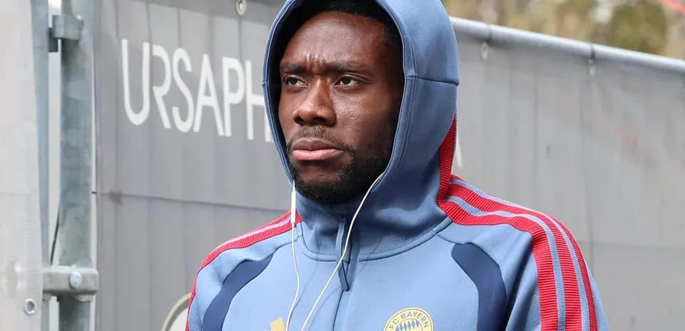 Player wearing Bayern Munich hoodie walking with headphones