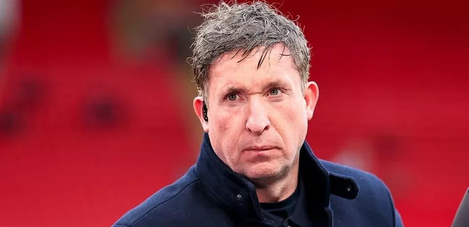 Man in a coat at a football stadium