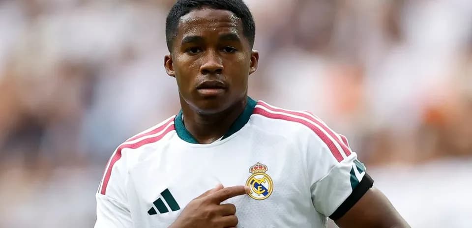 Player pointing to Real Madrid logo on jersey