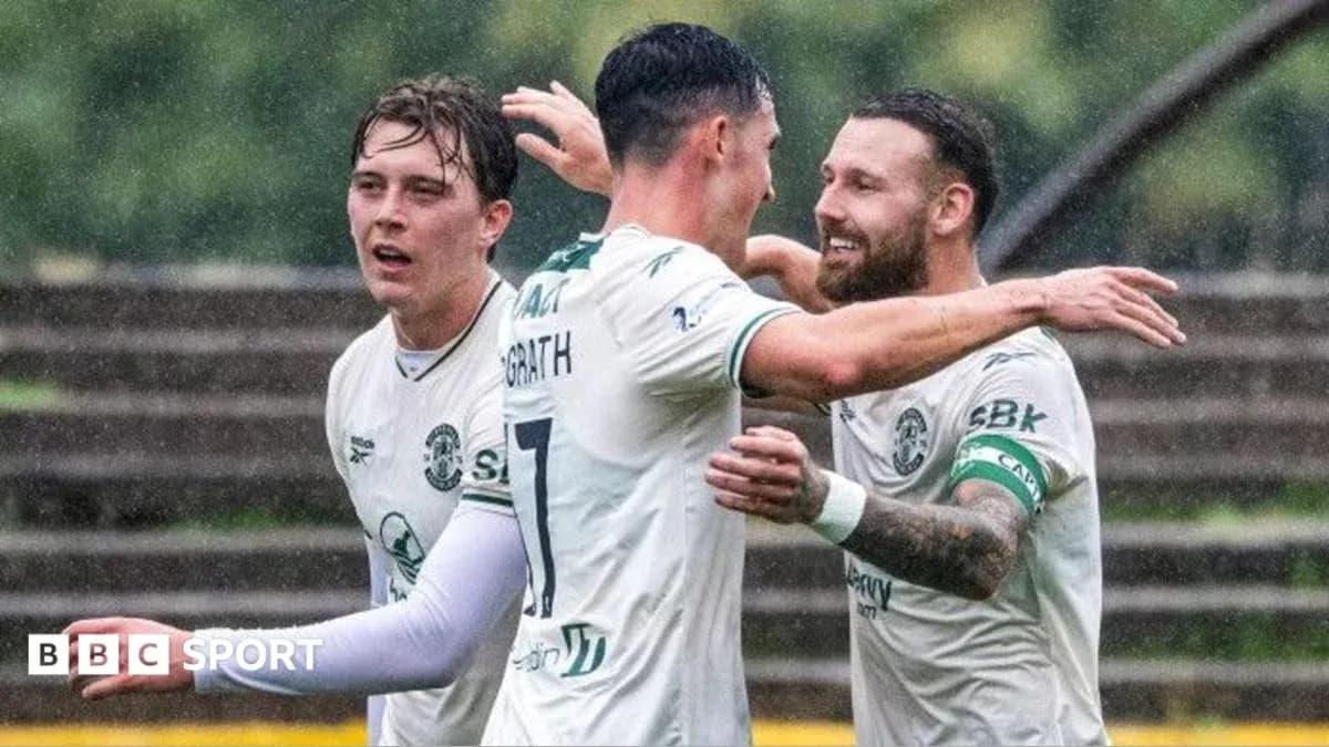 Players celebrating a goal in the rain