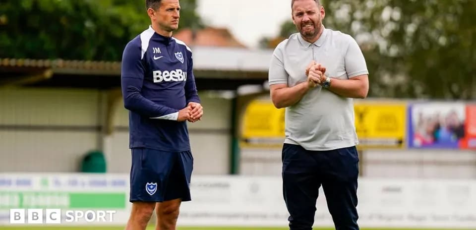 Two coaches discussing strategies on training pitch