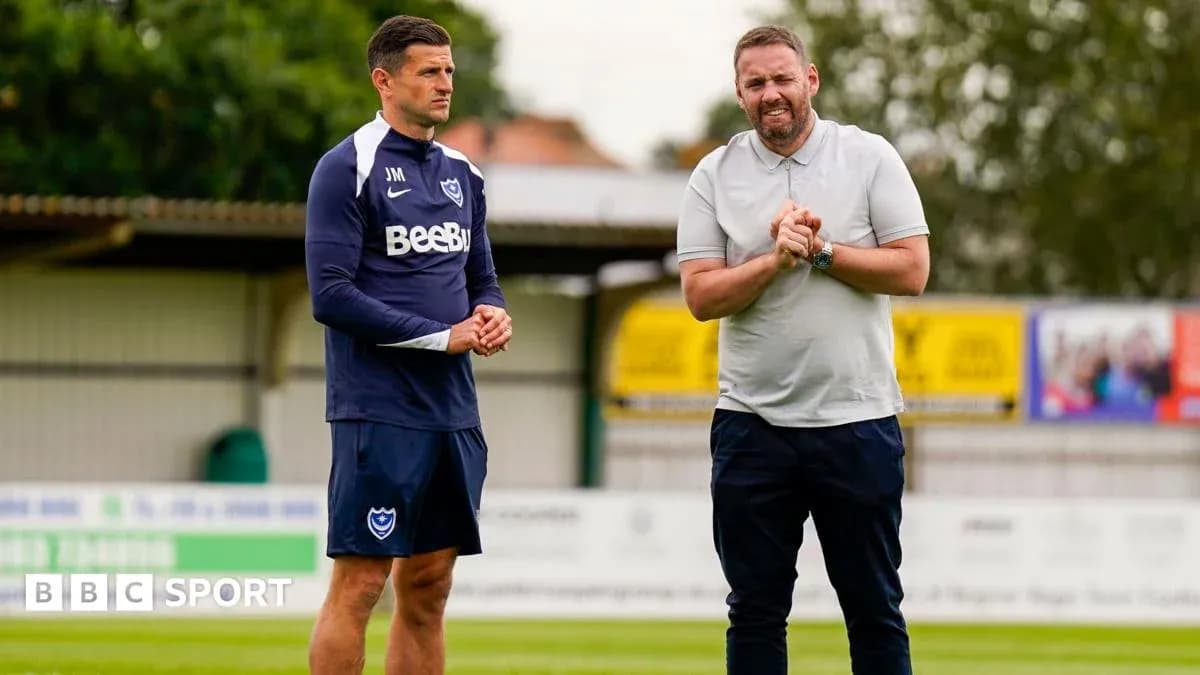 Two coaches discussing strategies on training pitch