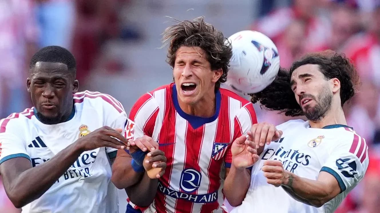 Players from Atlético and Real Madrid contesting a header