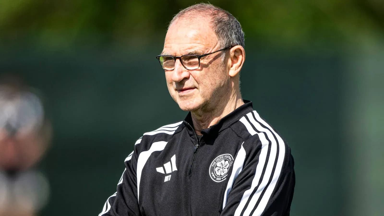 Manager observing players during training session