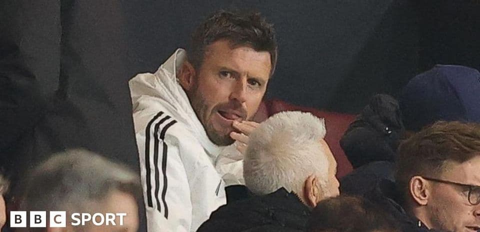 Man in white jacket watching a match in stands