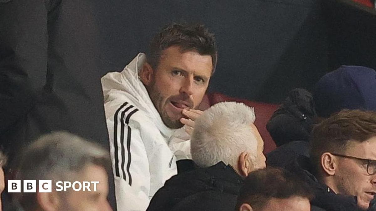 Man in white jacket watching a match in stands
