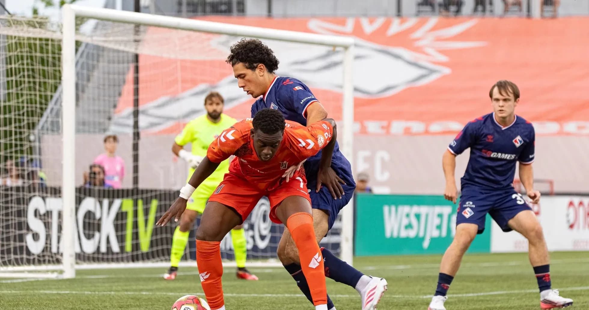 Players competing for the ball in football match
