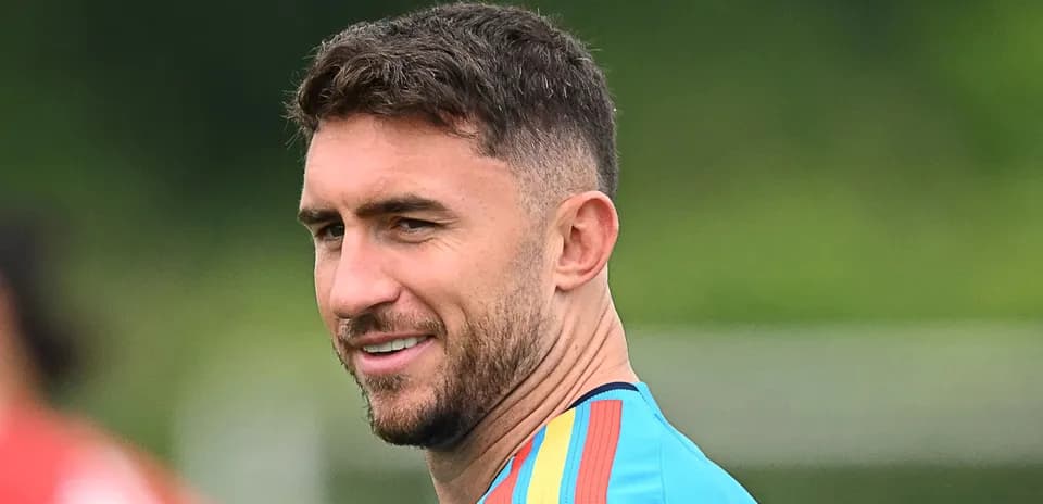 Football player in training kit smiling outdoors