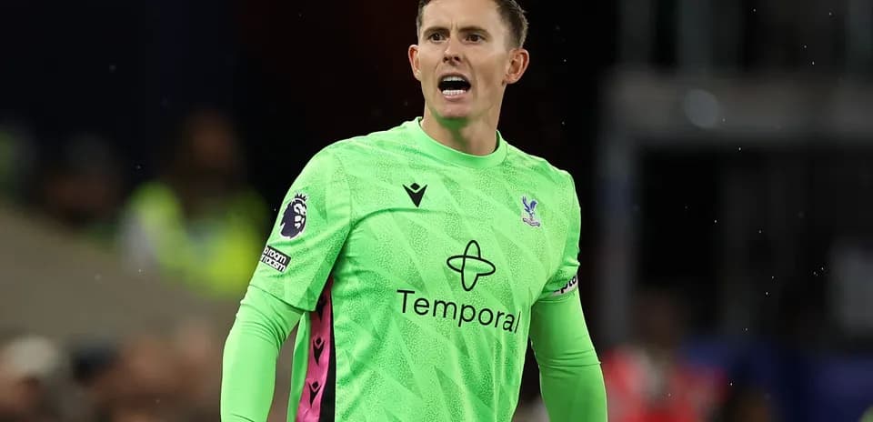 Goalkeeper in green kit shouting during match