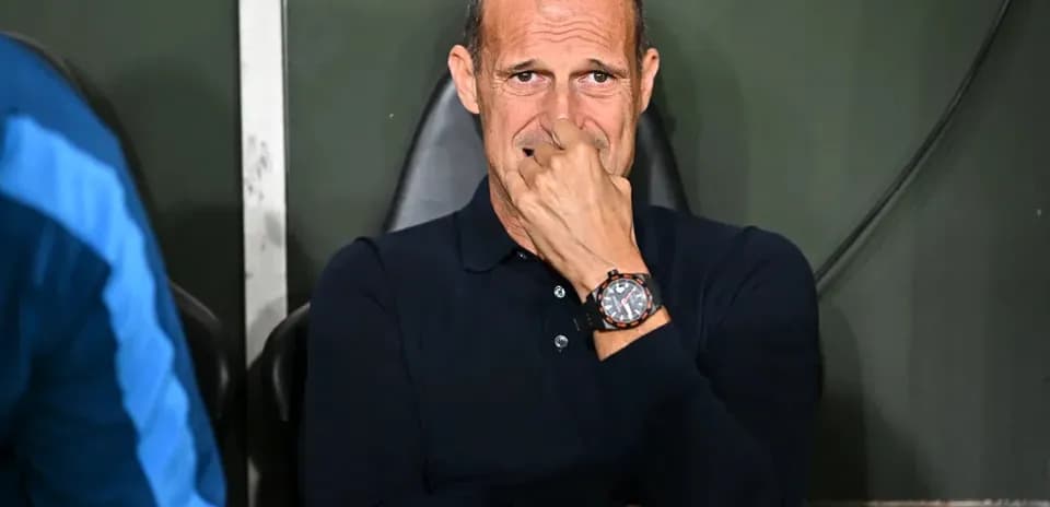 Coach sitting on bench during match, looking concerned