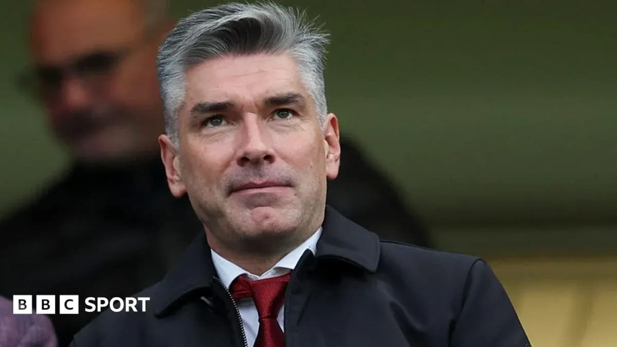 Man in suit observing from the stands at a match