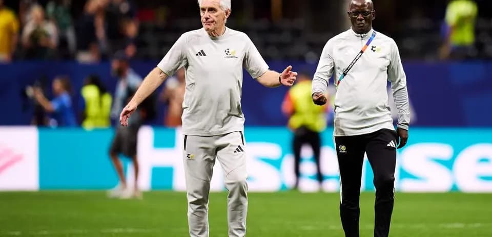Two coaches walking on the pitch before a match