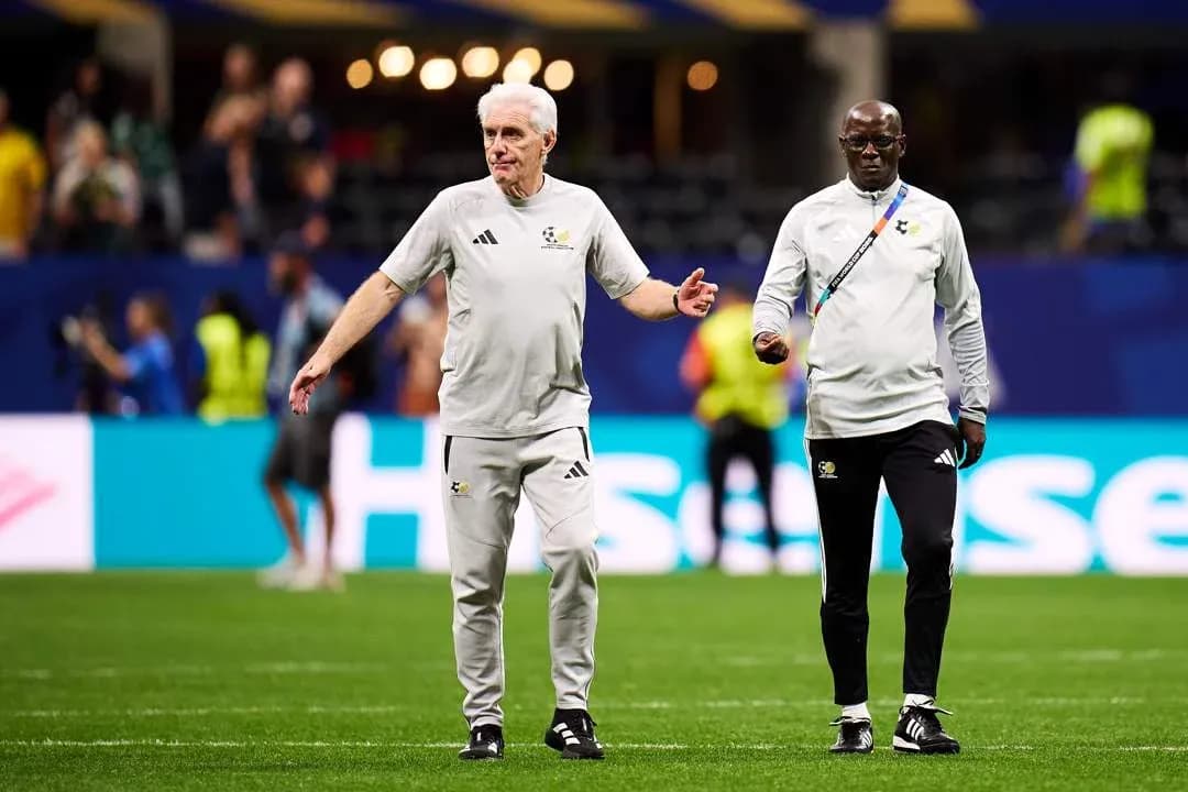 Two coaches walking on the pitch before a match