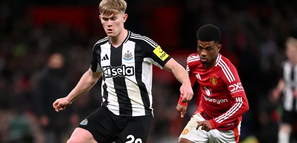 Newcastle player evading Manchester United opponent during match