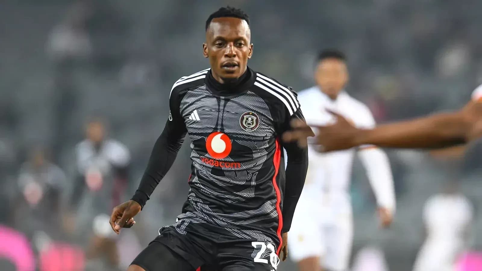 Player in black kit running on the field
