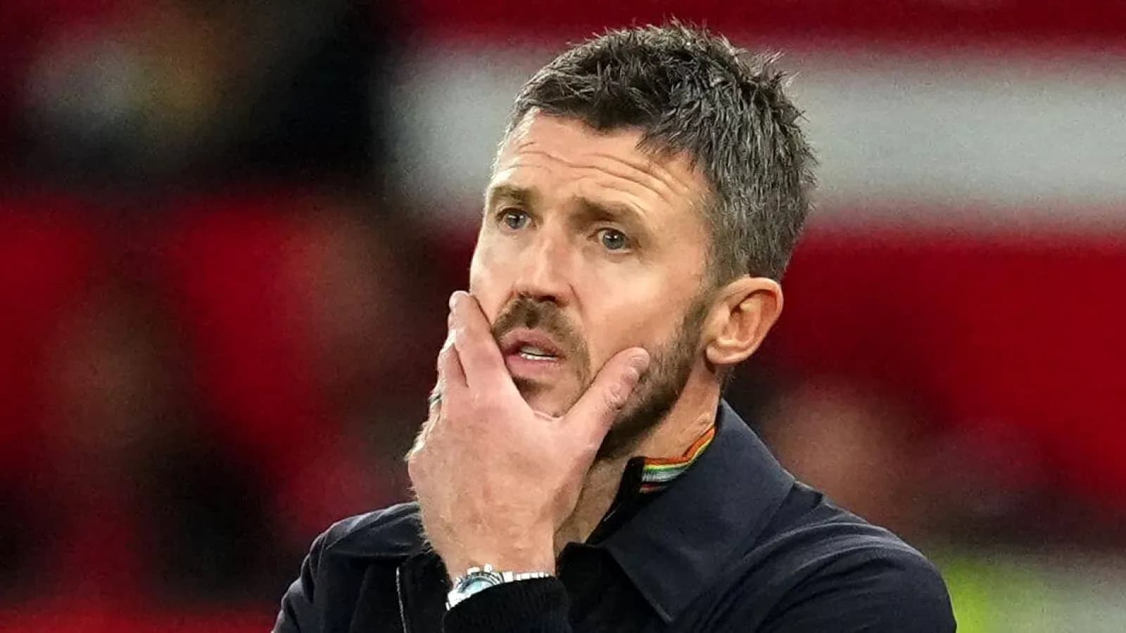 Coach contemplating during a match on the sidelines