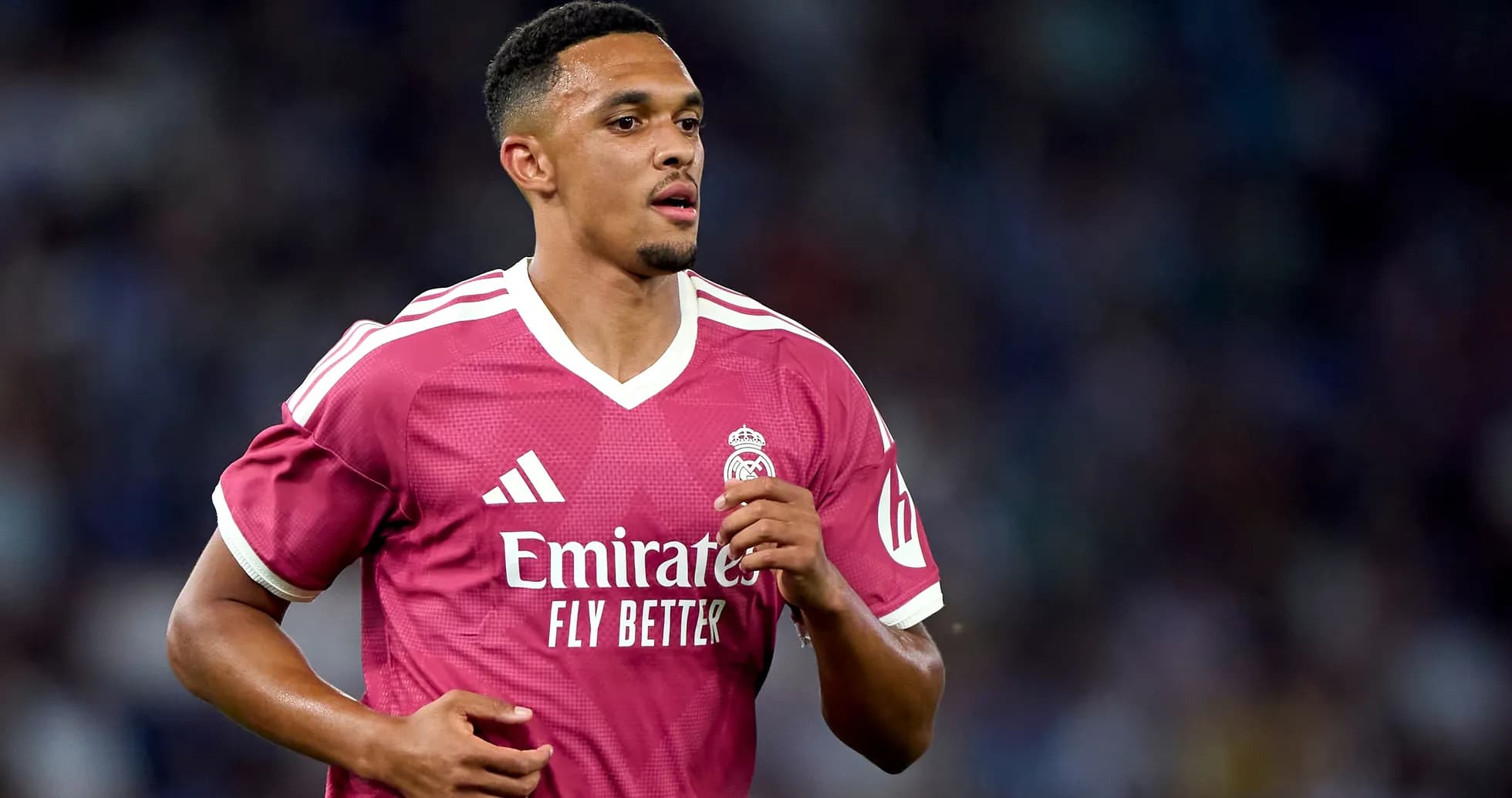 Player running in pink Real Madrid jersey during match