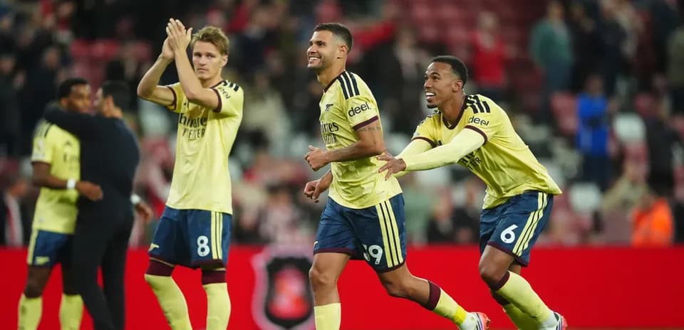 Players celebrating victory in yellow jerseys on pitch