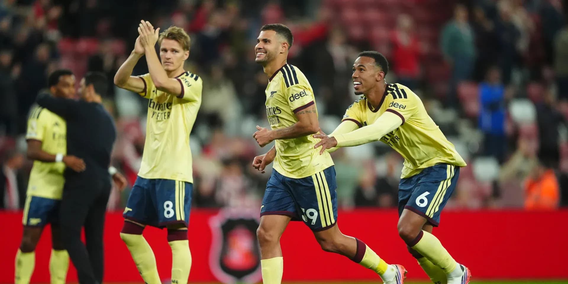 Players celebrating victory in yellow jerseys on pitch