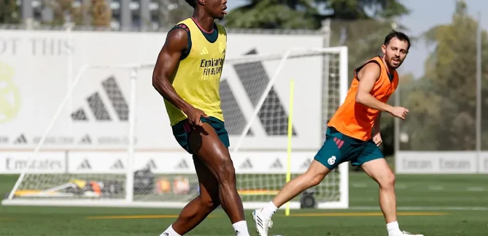 Two players training on pitch with goal in background