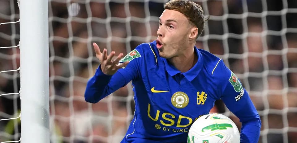 Player gesturing while holding a football in goal