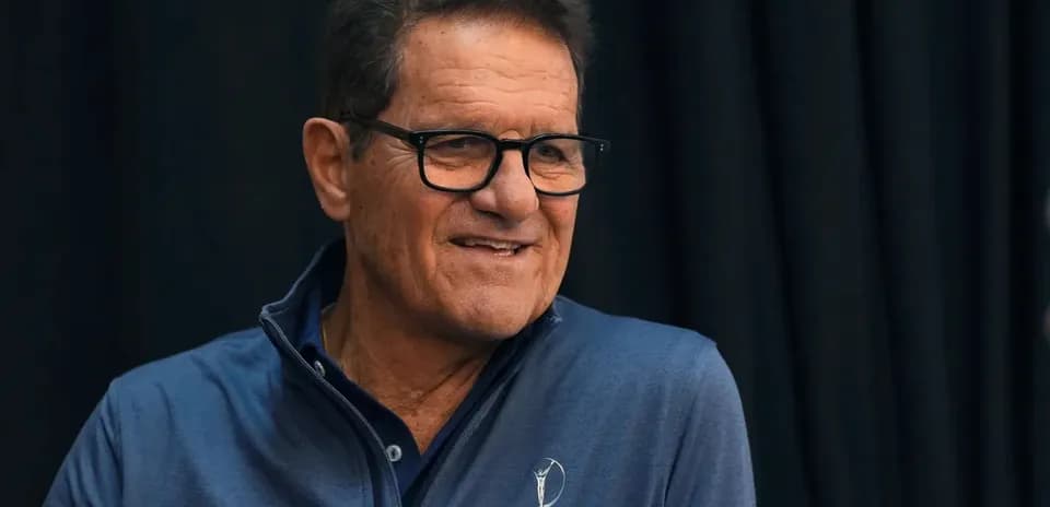 Man smiling during a press conference appearance